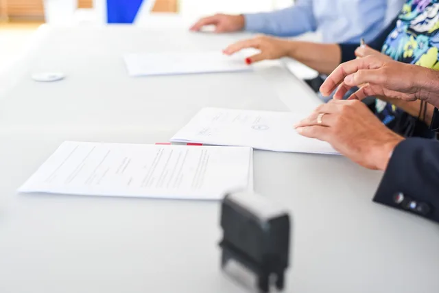 agreement, contract signing, table, hands, sign, contract, paper, paper work, meeting, business, closeup, agreement, contract, contract, contract, contract, contract. Following up when a licensed use exceeds the agreement